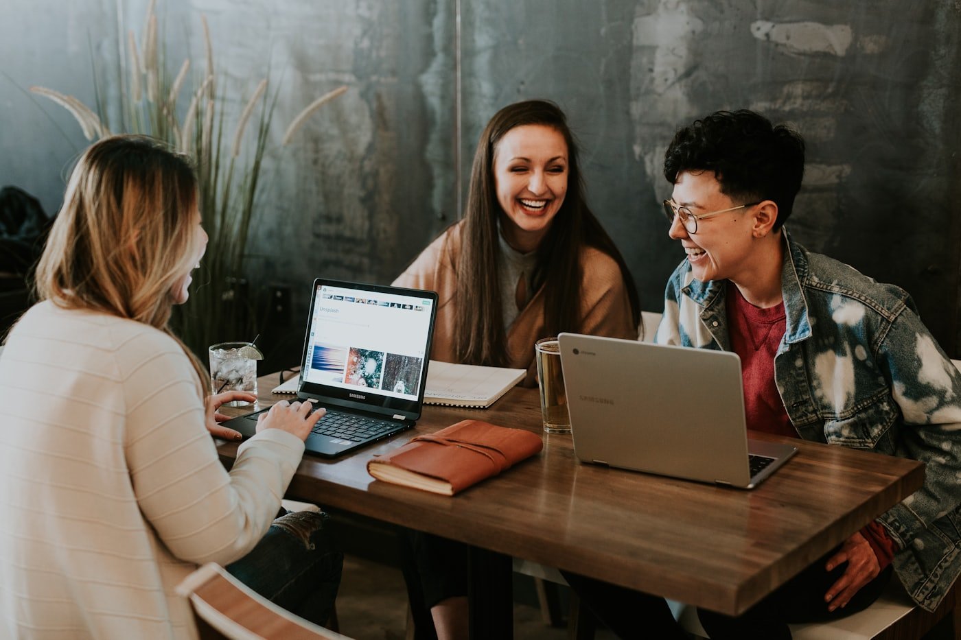 Three founders talking and laughing around a table