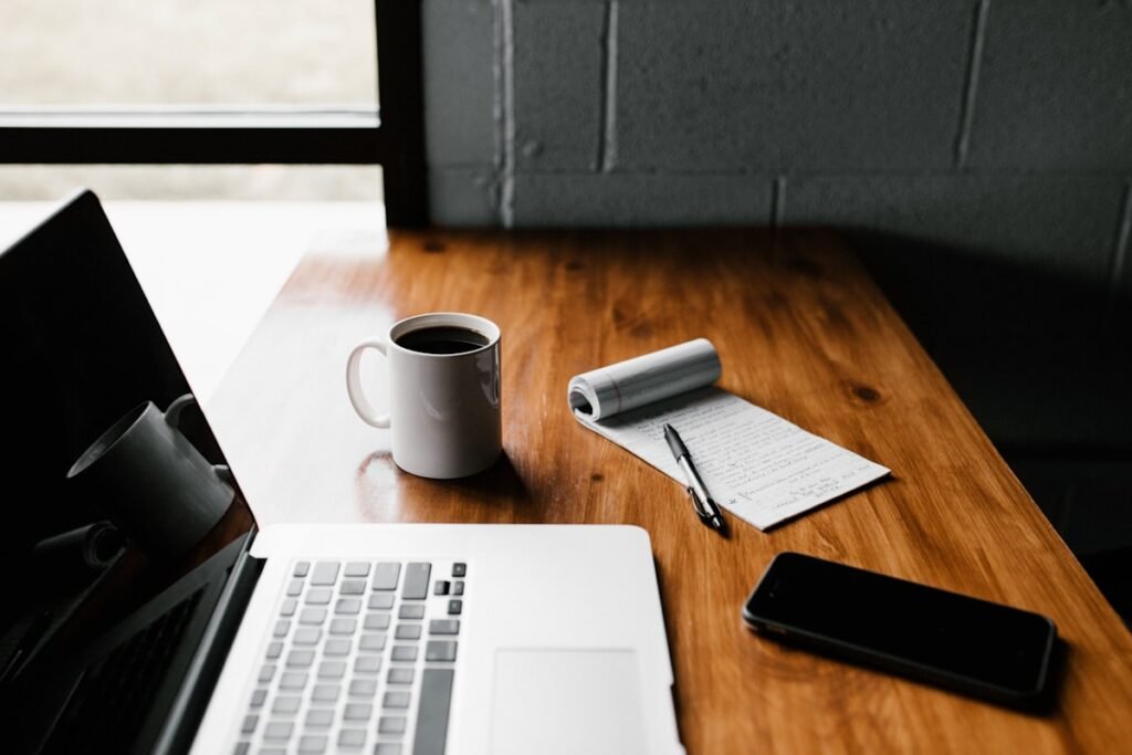 A desk with a laptop and notebook