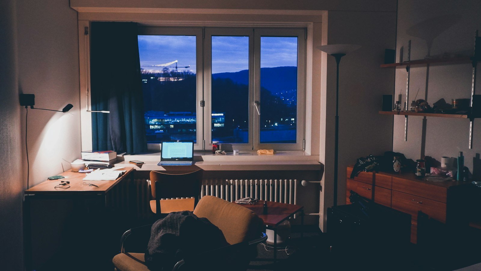 Desk with a laptop in a home office at night, the view a professional starting a business at 40 works from after hours